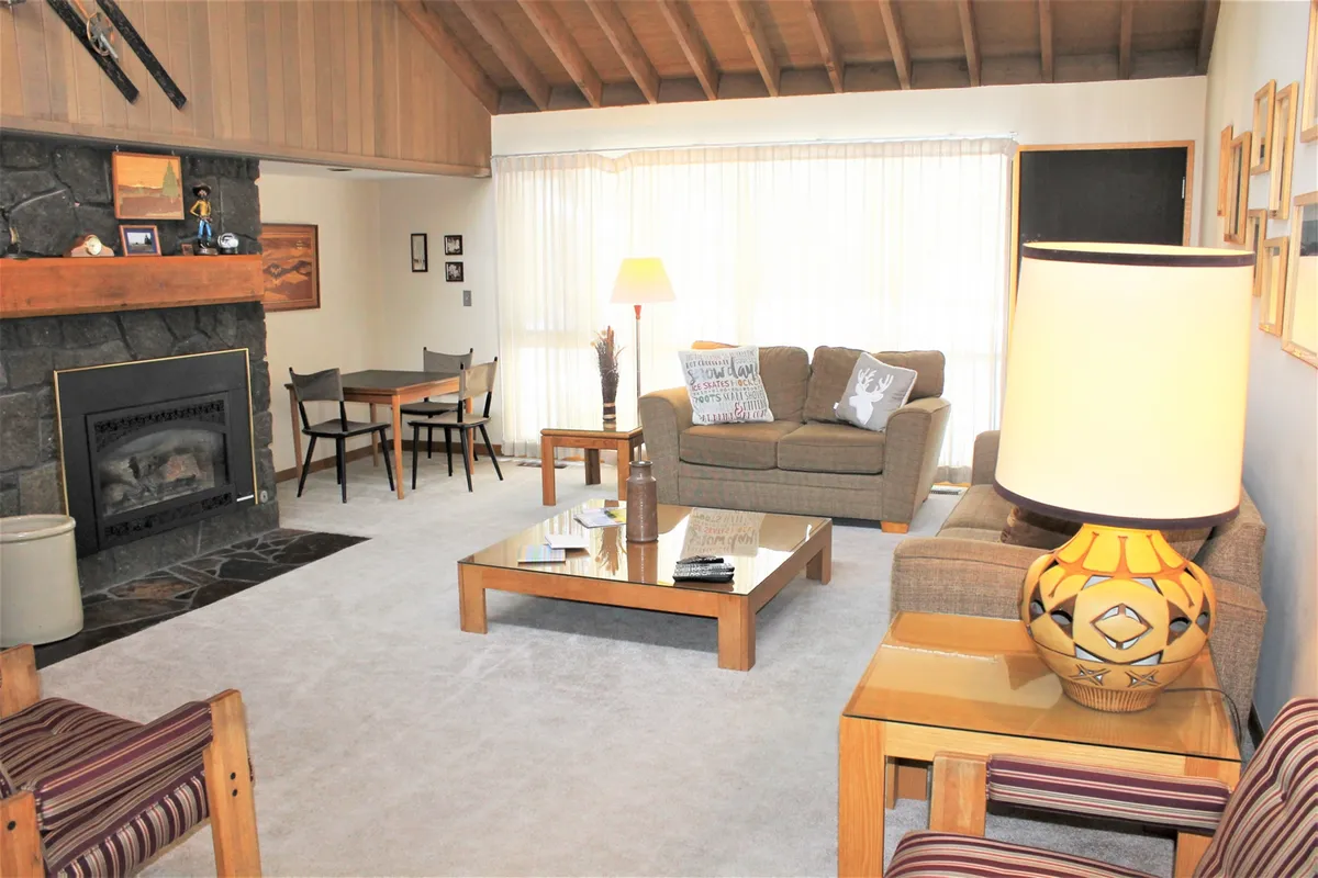 A cozy living area with a fireplace, soft sofa, coffee table, and lamp, perfect for unwinding after a day of recreation. The warm ambience reflects a space for relaxation, socializing, and creating memories with loved ones.