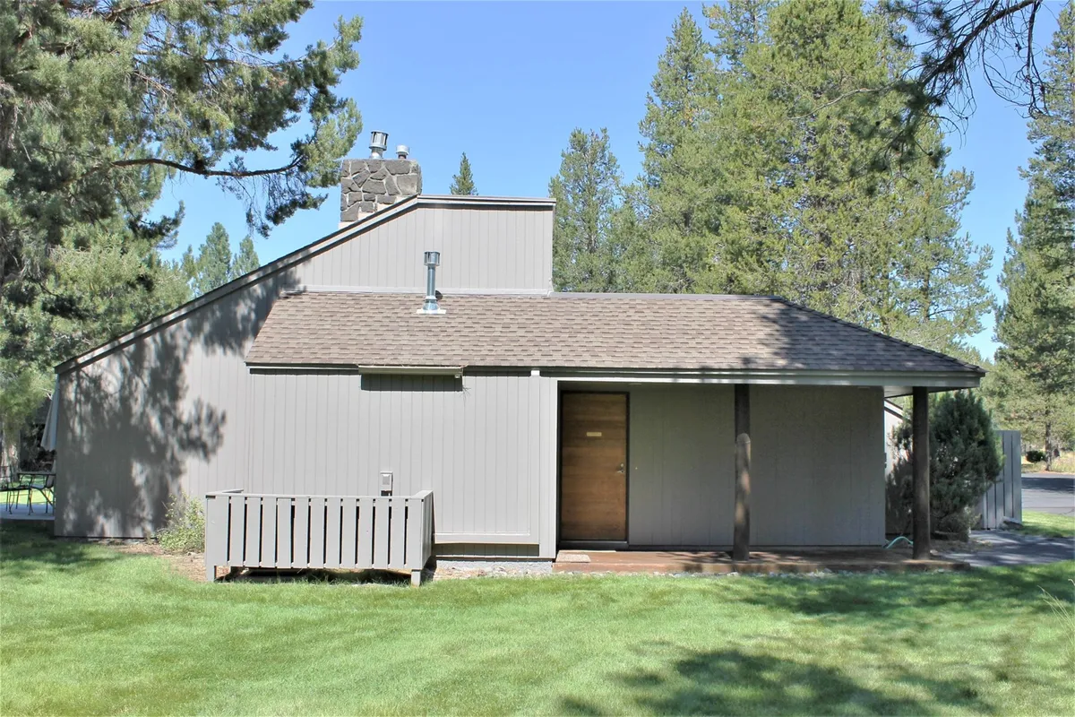 This scene shows the front of Meadow House 58, highlighting both the entryway and an inviting deck space. The sloped roof and open yard area suggest ample space for outdoor activities or family gatherings. The image captures the peaceful ambiance of the property's exterior and its welcoming presence.